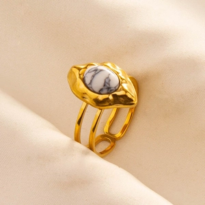 Detailed macro view of an adjustable gold-plated ring with a white marble stone and lava texture