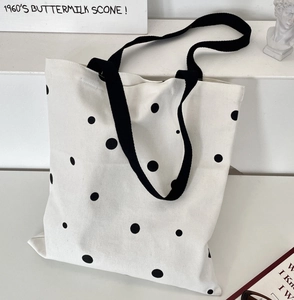 Close-up of a large capacity white canvas tote bag with retro black polka dots print