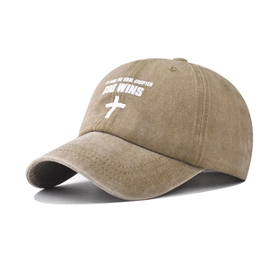 Détail d'une casquette en coton délavé avec croix blanche et texte God Wins imprimé