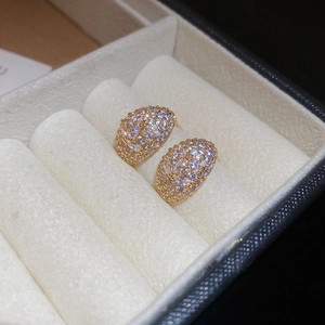 Macro shot of gold moon-shaped earrings featuring luxury zircon pavé in a jewelry box