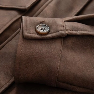 Detail of dark brown faux suede cuff with high-quality amber button and fine stitching