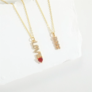 Golden cross chain necklaces featuring crystal LOVE and BOSS pendants with a red heart gem