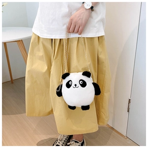 Detail of plush panda shoulder bag with gold metal chain on a model wearing a white shirt