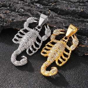 Gros plan détaillé du pendentif scorpion hip-hop serti de cristaux sur roche noire