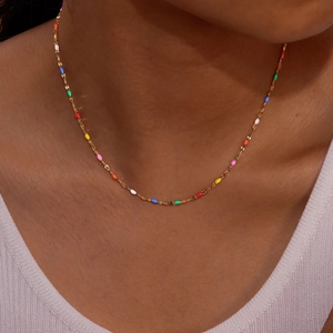 Gold-plated stainless steel chain necklace with colorful oval enamel beads on a female model