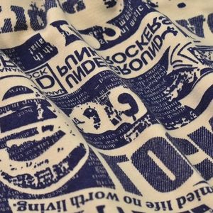 Macro shot of punk rockers newspaper print on cream soft knit beanie fabric texture