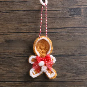 Detailed view of handmade knitted gingerbread man ornament with a red polka dot bow