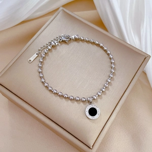 Close-up of titanium steel beaded bracelet with black agate pendant and sparkling pavé crystals