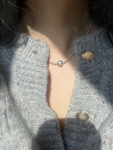 Close-up of minimalist stainless steel beaded necklace with pearl pendant on model