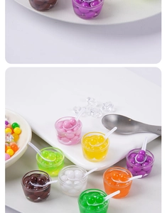 Macro-opname van miniatuur fruitdessertbekers met gekleurde harsballen en kleine lepels