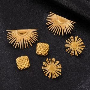 Macro shot of three pairs of geometric gold plated stainless steel studs on black texture