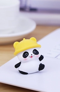 Close-up of cute panda figurine with yellow hat on office desk for cozy decor