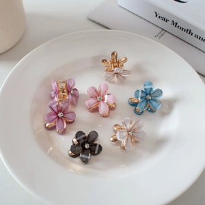 Sweet 7-piece flower hair claw set with rhinestones on a decorative white plate