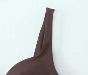 Detailed close-up of dark brown elastic shoulder straps and neckline on a mini dress