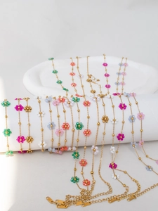 Detail of colorful beaded flower charms on gold stainless steel chains with lobster clasps