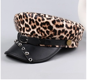Detail view of leopard print newsboy cap with leather strap and silver rivet accents