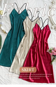 Detail view of satin sleepwear showing smooth textures in peacock green and burgundy