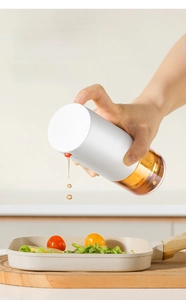 Action shot of glass oil dispenser with air vent for precise flow and leak-proof pouring