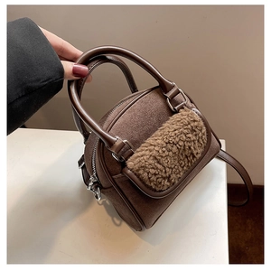 Detail view of dark brown tote bag featuring plush trim and matte suede texture