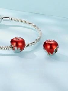 Macro shot of an S925 sterling silver Christmas apple charm with red enamel glaze