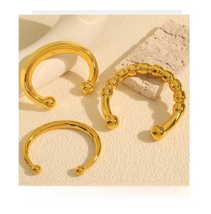 Detailed view of three gold open bangles with distinct smooth and wavy textures