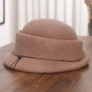Detail of camel wool felt hat featuring a black metallic bead chain and tassel decor