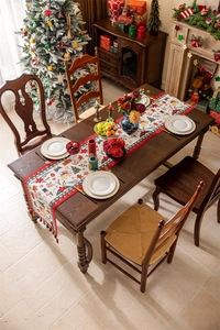 Christmas table runner with festive patterns on a wooden dining table in a cozy room