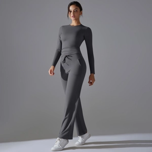 Détail d'un ensemble de yoga gris foncé avec haut à manches longues et pantalon évasé à cordon