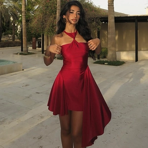 Detail of red halter dress featuring a front twist knot and asymmetric ruffled hemline