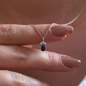 Collana a catena dorata con pendente in zaffiro blu a goccia e dettagli in diamanti