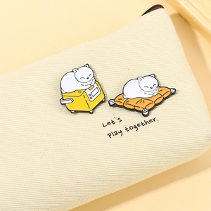Cute enamel cat pins featuring cats on a toaster and cushion on a canvas bag
