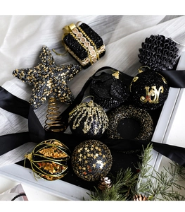 Detail of black and gold Christmas ornaments set with star topper and glitter baubles