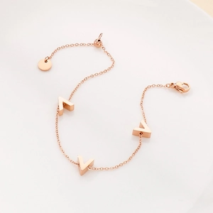 Detail of rose gold V-shaped charms on minimalist adjustable titanium steel chain