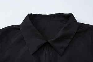Close-up of the collar detail on a black short-sleeved button-up shirt for women