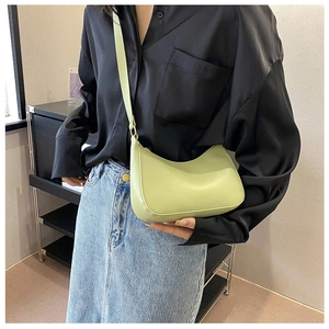 Primer plano del bolso de hombro minimalista verde crema con forma de media luna