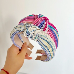 Detail of silk rainbow striped knotted headband with colorful satin fabric texture