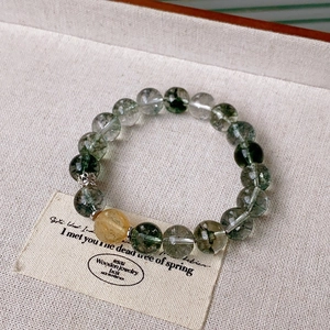 Detail of green rutilated quartz beaded bracelet with yellow crystal and silver accents