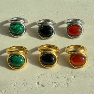 Close-up of vintage 18k gold plated titanium rings with green malachite and black gemstones