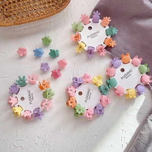 Close-up of matte macaron color mini hair claws in flower and crown shapes on card
