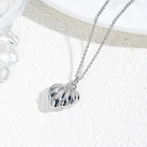 Macro shot of silver-plated hollow pumpkin heart pendant on an O-chain necklace