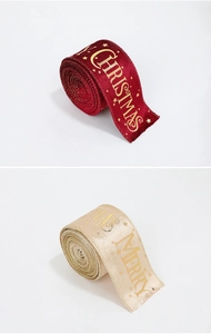 Detail of red velvet and champagne satin ribbons with gold Merry Christmas printing