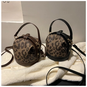 Detail showing vintage leopard print barrel bags in black and brown with gold hardware