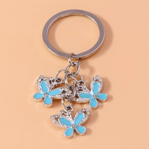 Detail of three blue enamel butterfly charms with rhinestones on a metal keychain