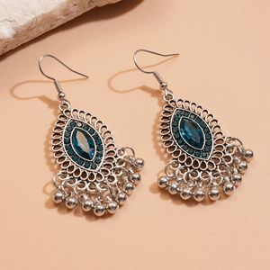 Detail of silver bohemian drop earrings with blue marquise stones and metal fringe