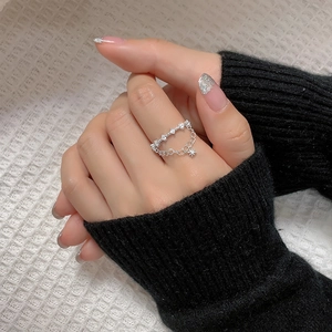 Detail of silver shooting star double layer ring with zircon stones and star charm
