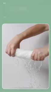 Close-up of hands wringing a wet compressed face towel to show strong water absorption