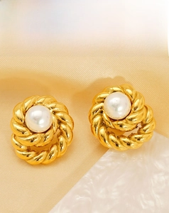 Detailed macro of gold twisted rope texture earrings with elegant white round pearls