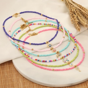 Bohemian multilayer bead necklace set with evil eye pendants on a white display tray
