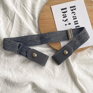 Detail of adjustable dark grey elastic belt with metal buckle on a wooden plate