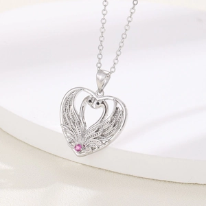 Silver swan heart pendant necklace with pink gemstone on a white pedestal stand